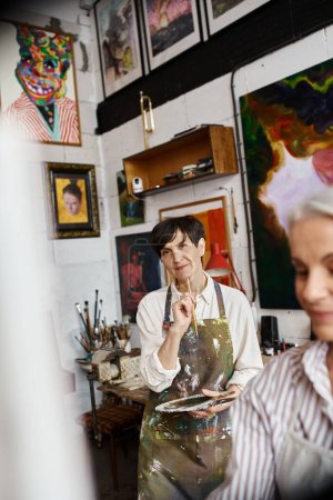 Foto de Dos mujeres pintando en un estudio de arte. - Imagen libre de derechos