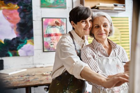 Dos mujeres abrazándose activamente en el estudio de arte.