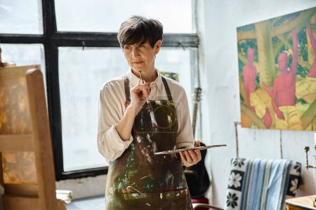 Frau im Kunstatelier schafft mit Pinsel.