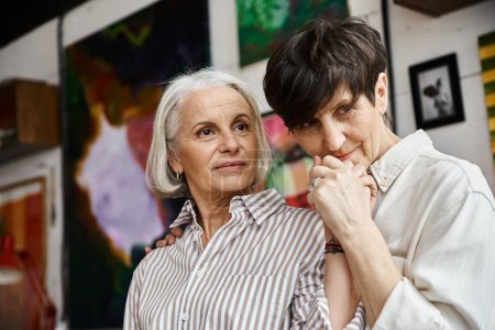 Foto de Dos mujeres de pie lado a lado en un estudio de arte. - Imagen libre de derechos