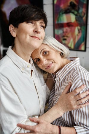 Foto de Two women in front of vibrant paintings. - Imagen libre de derechos