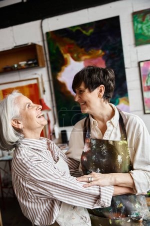 A mature lesbian couple working together in an art studio.