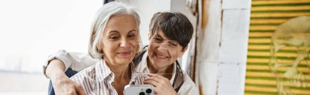 Photo for Two women taking a self-portrait with smartphone. - Royalty Free Image