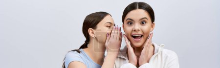 Photo for Two pretty, brunette teenage girls in sportive attire, making funny faces and gestures with their hands. - Royalty Free Image