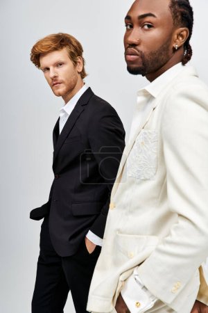 Photo for Two multicultural men in stylish suits standing next to each other. - Royalty Free Image
