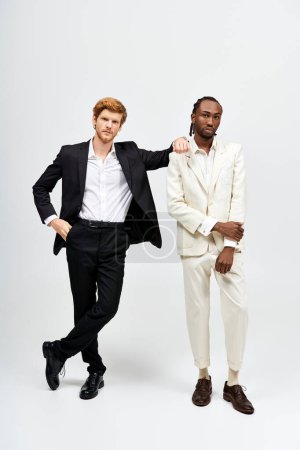 Dos hombres multiculturales en trajes elegantes de pie juntos.