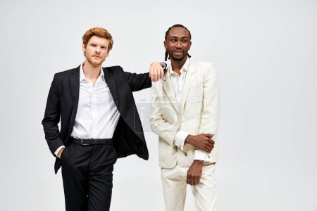 Two multicultural men in elegant suits stand together.