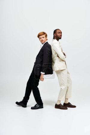 Zwei multikulturelle Männer in eleganten Anzügen posieren gemeinsam.