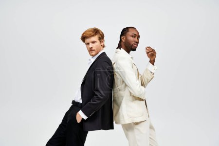 Téléchargez les photos : Deux hommes multiculturels en costumes élégants se tiennent côte à côte. - en image libre de droit
