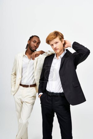 Téléchargez les photos : Deux beaux hommes en costumes sur mesure se tiennent élégamment côte à côte. - en image libre de droit