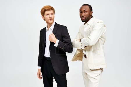 Foto de Dos hombres multiculturales en trajes elegantes están uno al lado del otro. - Imagen libre de derechos
