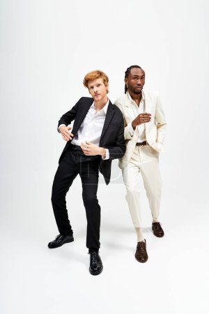 Zwei multikulturelle Männer in stylischen Anzügen posieren selbstbewusst für die Kamera.