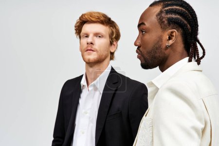 Zwei gutaussehende multikulturelle Männer in eleganter Kleidung stehen zusammen.