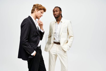 Two handsome multicultural men in elegant suits posing together.