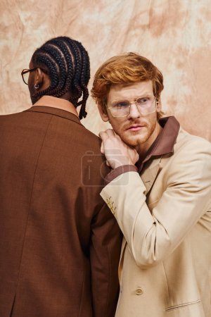 Téléchargez les photos : Des hommes multiculturels en lunettes et en trench-coat posent ensemble. - en image libre de droit