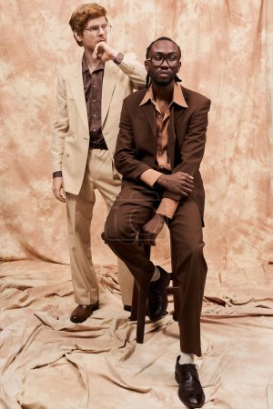 Foto de Dos hombres multiculturales en trajes elegantes posan juntos. - Imagen libre de derechos