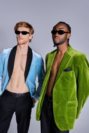 Two handsome men in elegant attire striking a pose together.