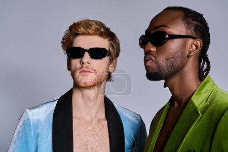Foto de Dos hombres multiculturales con gafas de sol posan uno al lado del otro. - Imagen libre de derechos