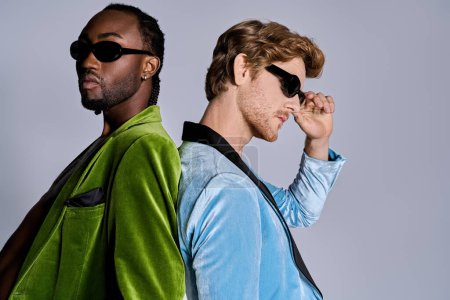 Two multicultural men in green jackets strike a pose in stylish sunglasses.