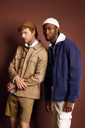 Foto de Dos hombres elegantes están junto a una pared marrón. - Imagen libre de derechos