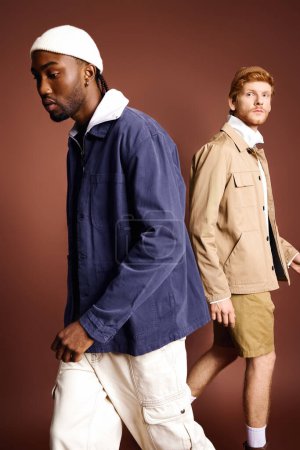 Zwei stylische Männer in Jacken und kurzen Hosen spazieren gemütlich zusammen.