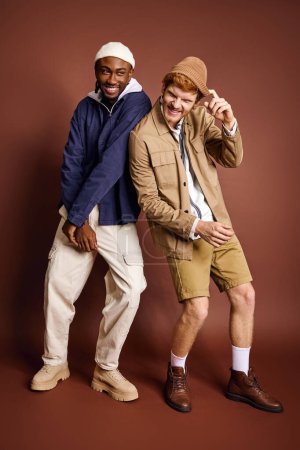 Multikulturelle Männer in stylischer Kleidung posieren gemeinsam für ein Foto.