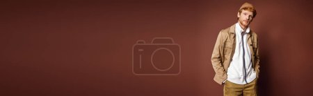 Photo for A stylish man standing confidently in front of a vibrant red wall. - Royalty Free Image
