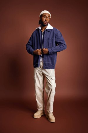 Foto de Un joven afroamericano guapo con chaqueta azul y pantalones blancos. - Imagen libre de derechos