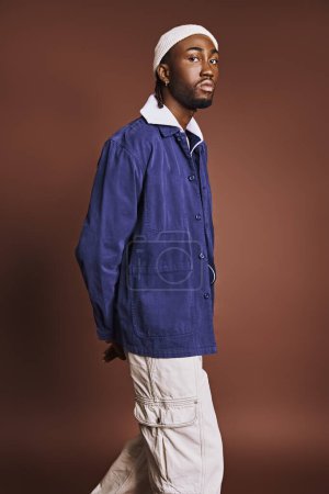 Photo for Handsome young African American man in blue jacket and white pants, confidently strolling. - Royalty Free Image