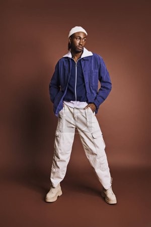 Photo for An African American man stands with hands on hips in a stylish outfit. - Royalty Free Image