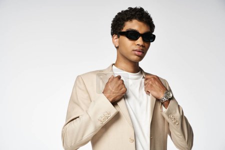 Handsome African American man wearing sunglasses and a stylish tan suit.