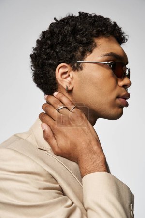 Foto de Hombre afroamericano guapo en traje bronceado, gafas de sol y anillo en el dedo. - Imagen libre de derechos