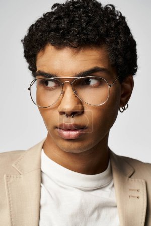 Beau Afro-Américain aux cheveux bouclés portant des lunettes tendance.