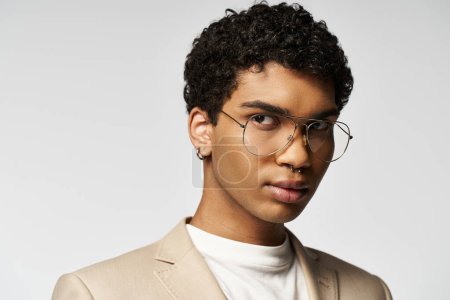 Handsome African American man in tan suit and stylish glasses.