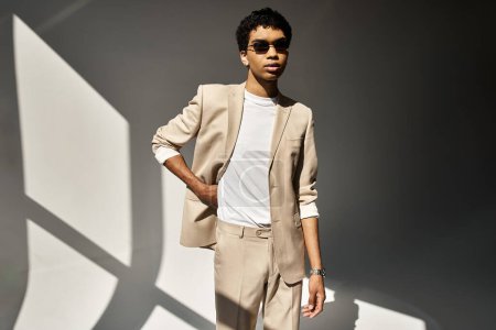 Téléchargez les photos : Handsome African American man looking stylish in a beige suit and sunglasses. - en image libre de droit