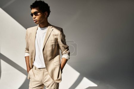 Photo for Handsome African American man in tan suit and sunglasses strikes a confident pose. - Royalty Free Image