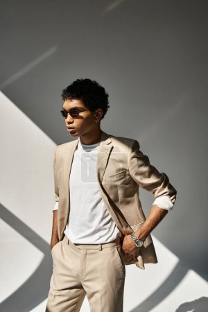 Stylish African American man in tan suit and trendy sunglasses.