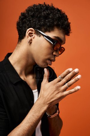 Schöner afroamerikanischer Mann mit Sonnenbrille und schwarzem Hemd.