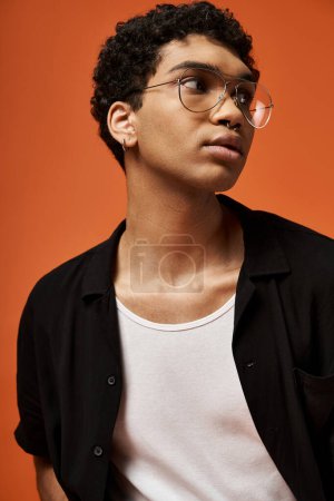 Téléchargez les photos : Beau jeune homme afro-américain en chemise noire et lunettes élégantes. - en image libre de droit