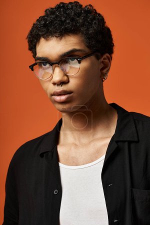 Joven hombre afroamericano con gafas elegantes y camisa negra.