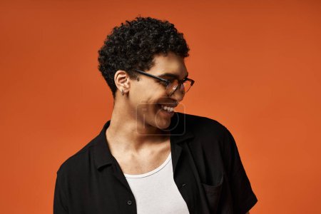 Handsome African American man in sunglasses and black shirt smiles warmly.