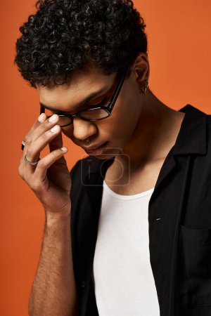 Handsome young African American man in black shirt and stylish glasses.