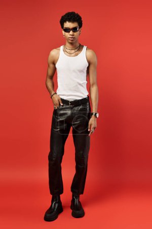 Foto de Handsome man in black leather pants striking a pose with cool shades - Imagen libre de derechos