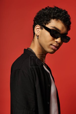 Schöner junger Mann mit Sonnenbrille und schwarzem Hemd.