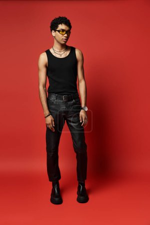 Young man in black leather pants and tank top with stylish sunglasses.