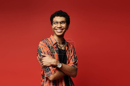 Téléchargez les photos : Jeune homme souriant revêtant des lunettes et chemise à carreaux - en image libre de droit