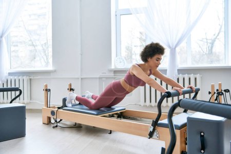 A woman in a pink top works out, pilates.