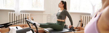 Photo for Woman in pilates pose in sportswear next to her friend. - Royalty Free Image