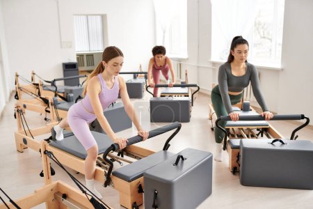 Vielfältige Gruppe von Frauen, die gemeinsam in einem dynamischen Fitnessstudio trainieren.