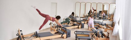 Alluring women engage in a Pilates session in a gym.